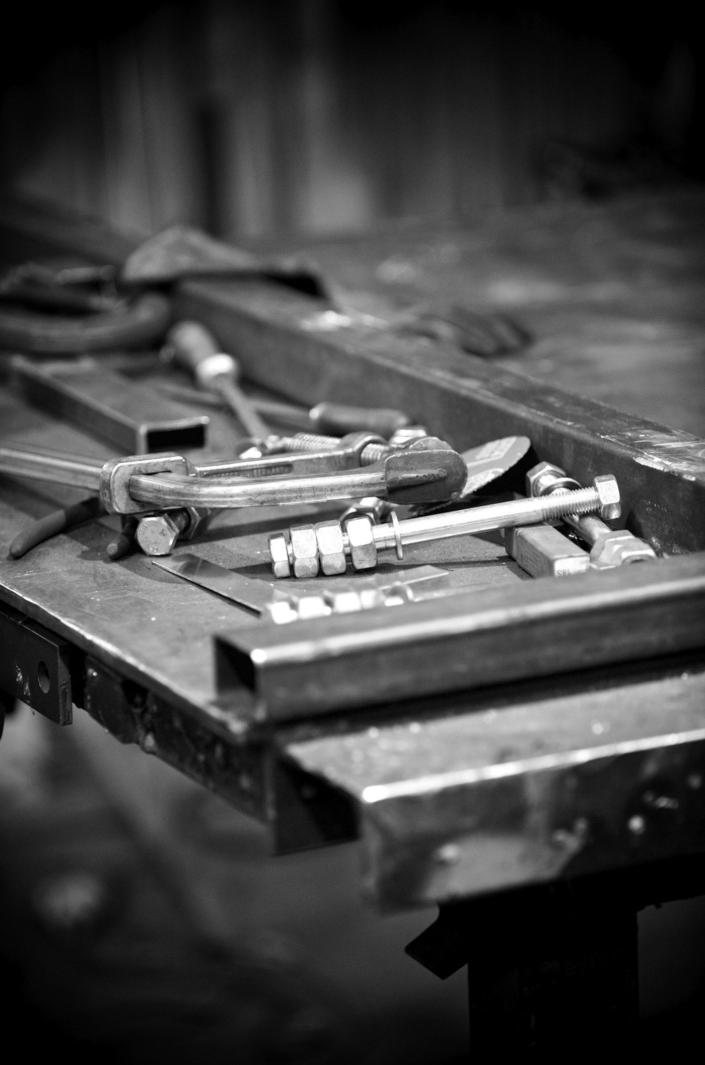 Mil-spec hex bolts, nuts and washers on a steel workbench